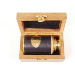 A small brass two draw telescope in a fitted wooden box, 3½" long