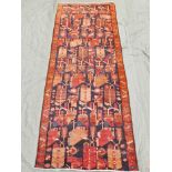 A deep blue and tomato ground Persian runner with all over design, 53½" x 138"