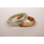 A Chinese mottled green hardstone bangle, and another similar, 3" diameter