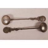 A pair of Chinese white metal spoons, the bowls and knops formed from coins, 6½" long