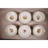 A part hand painted porcelain dessert service with gilt rims and floral decoration, four tazzas