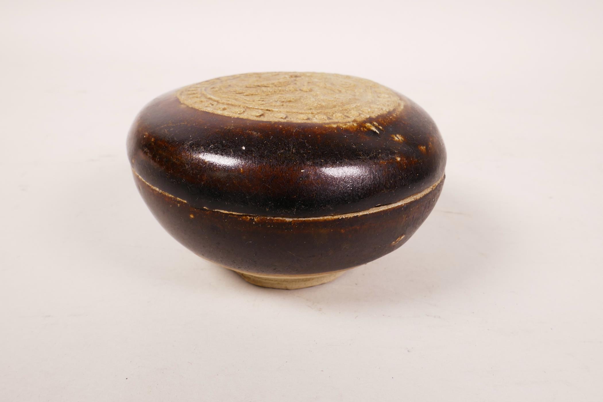 A Chinese Cizhou pottery box and cover with raised dragon decoration to cover, 3½" diameter