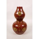 A Chinese porcelain double gourd vase with ochre lotus flower decoration on a red field, 6 character