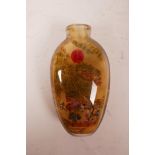 A Chinese reverse painted glass snuff bottle decorated with travellers in a landscape, 3½" high