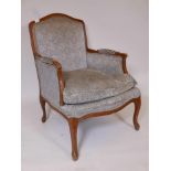 A French beechwood show frame armchair, raised on shaped supports
