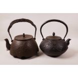An antique Japanese tetsubin cast iron kettle with raised decoration of Mount Fuji and galloping