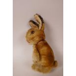 A 1952/53 Steiff begging rabbit, golden mohair, fixed limbs, brown and black glass eyes, red