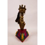 A Sino-Tibetan brass phurba in a carved and painted triangular stand, the handle decorated with