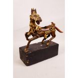 A Tibetan bronze censer in the form of a horse with gilt highlights, 10½" long