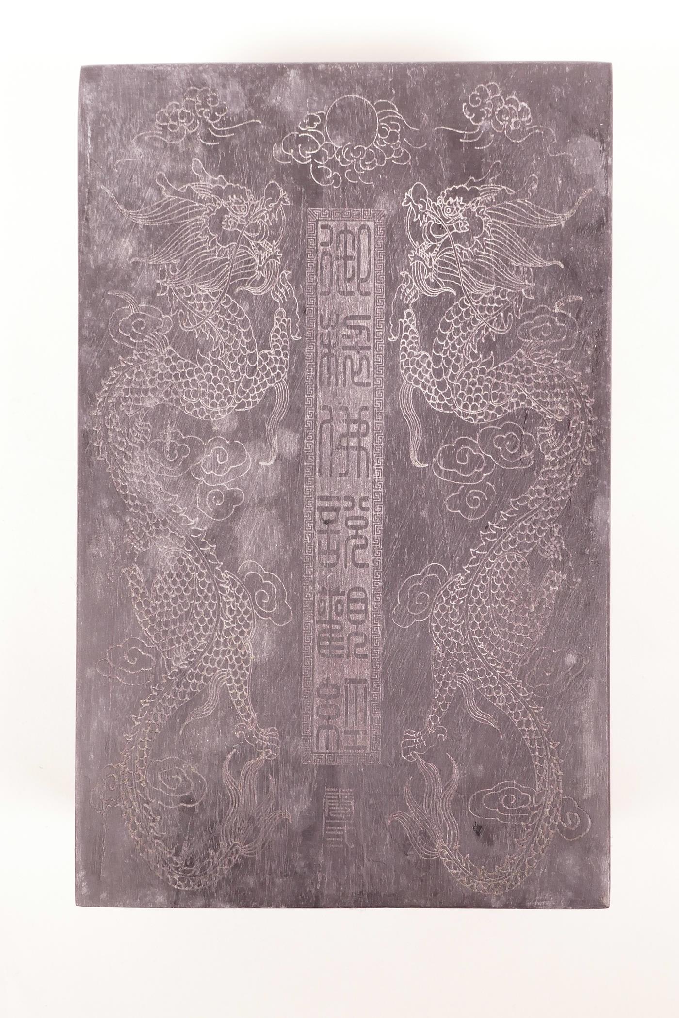 A Chinese silk and hardwood bound book containing white jade tablets with engraved and gilt