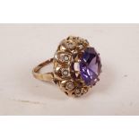 An untested gold and amethyst coloured stone ring, the stone encircled by diamond chips (probably