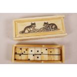 A set of miniature bone dominoes in a bone box, the top decorated with cats, 4¼" long