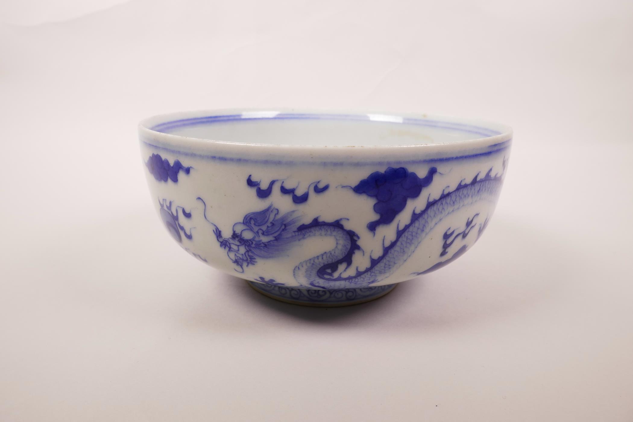 A Chinese blue and white porcelain bowl decorated with a dragon chasing the flaming pearl, 6 - Image 2 of 6