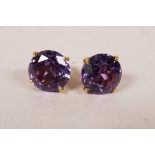 A pair of untested gold stud earrings set with large amethyst coloured stones, (possibly 18ct)