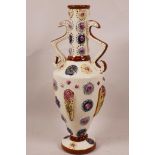 An English majolica urn style two handled vase with applied and embossed floral patterns on a