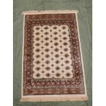 An ivory Kashmir rug, with a traditional Bokhara design, 45½" x 67"