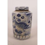 A Chinese blue and white pottery storage canister and cover, decorated with carp, 9" high x 6"