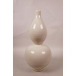 A Chinese cream ground porcelain double gourd vase with incised lotus flower decoration, 11" high