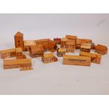 A quantity of wooden toy village houses and shops with painted decoration, church spire 9" high