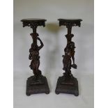 A pair of C19th carved walnut torcheres in the form of semi-clad maidens, raised on cushion bases,