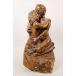 An art pottery figurine of a lovers' embrace mounted on a wooden plinth, 13½" high
