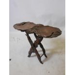 A Burmese late C19th/early C20th hardwood folding occasional table with well carved lotus flower and
