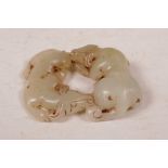 A Chinese celadon jade carved pendant in the form of two oxen, 3" x 2½"