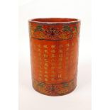 A Chinese red lacquer brush pot decorated with bats, lotus flowers and gilt character