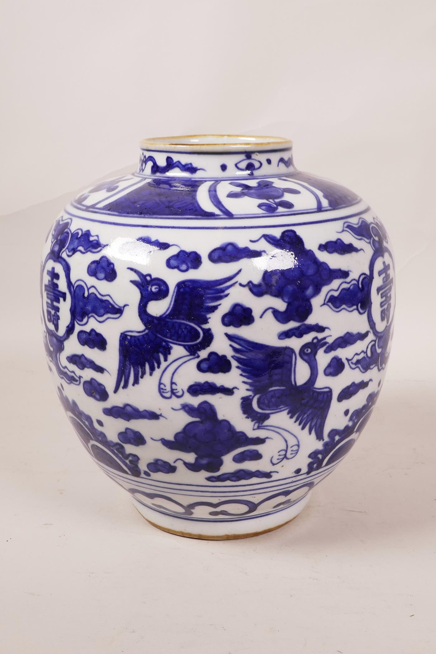 A Chinese blue and white porcelain ginger jar decorated with cranes in flight and auspicious