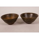 A pair of small Chinese bronze bowls with chased decoration of elephants and foliage, 2¼" diameter