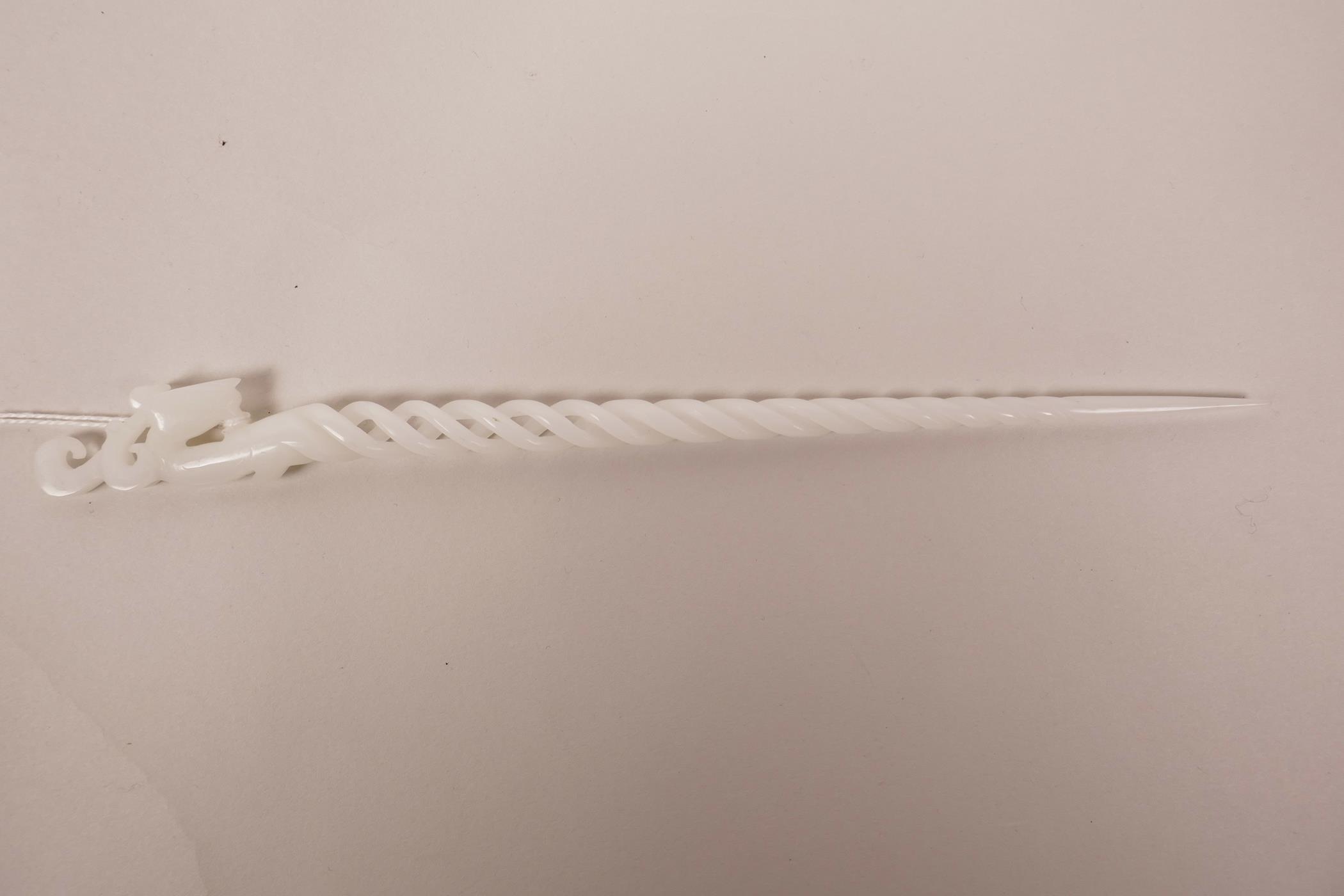 A Chinese white hardstone hair pin with a spiral stem and carved phoenix decoration, 9½" long