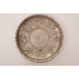 A Chinese white metal coin dish with raised decoration of the emblems of the Eight Immortals, 3½"