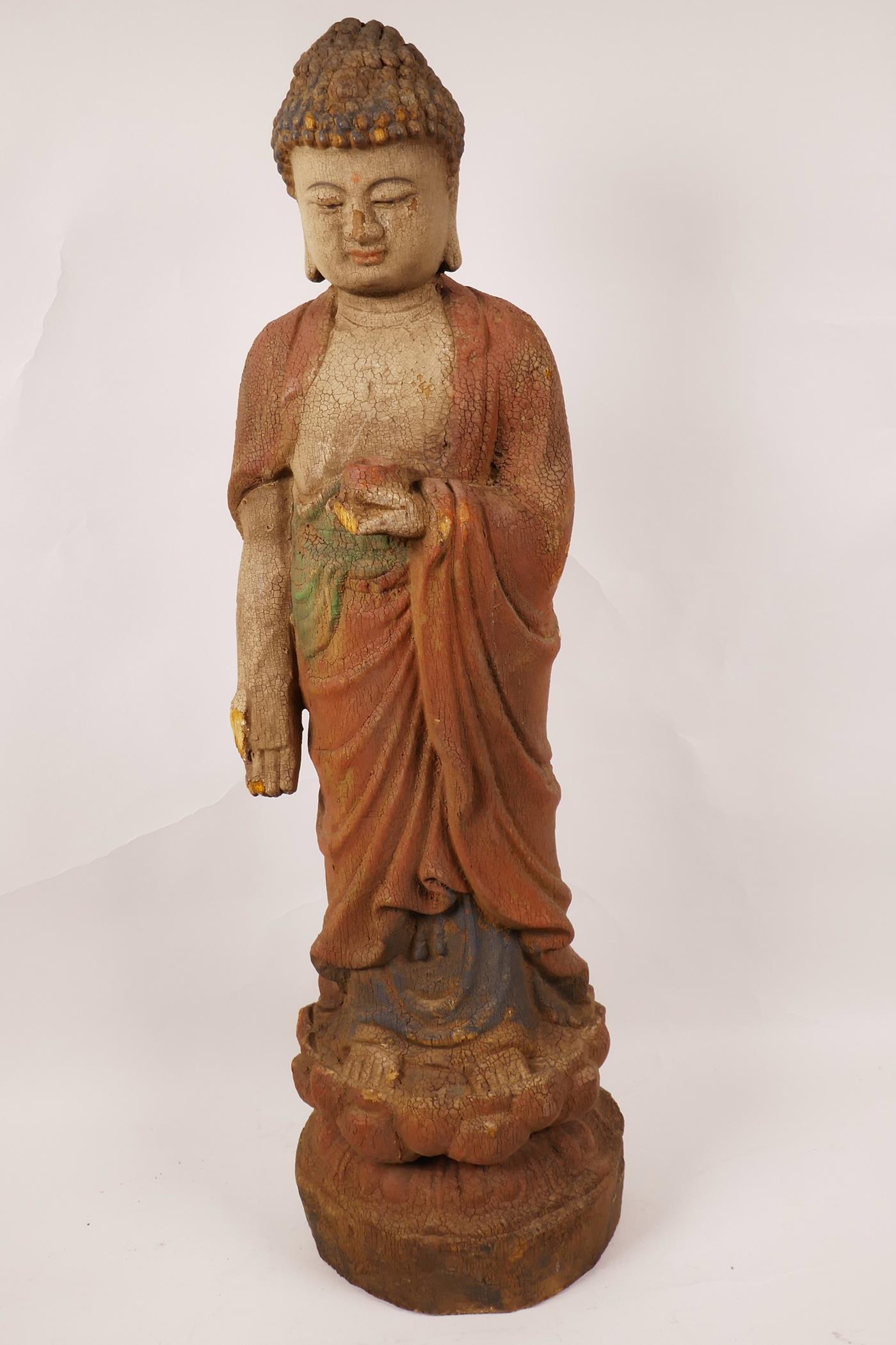 A painted wood figurine of Buddha standing on a lotus flower, 23" high