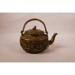 A Chinese bronze kettle with raised landscape and animal decoration and a fo dog knop, character