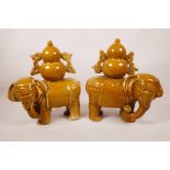 A pair of Chinese ochre glazed pottery elephants, 10" high