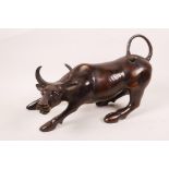 An Oriental bronze figurine of a bull, 11" long