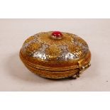 A Tibetan gilt washed white metal trinket box, the lid with a central set red stone encircled by