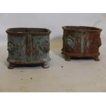 A pair of Victorian painted cast iron planters with lion mask decoration, raised on paw feet, one