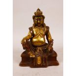 A Tibetan brass figure of Buddha seated on a throne with enamelled detail to the face, impressed