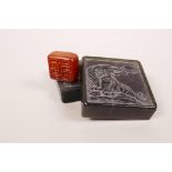 A Chinese green soapstone box containing an amber soapstone seal, the lid with carved tiger