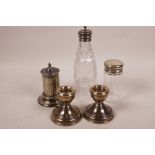 A pair of hallmarked silver dwarf candlesticks, together with a hallmarked silver pepperette, a