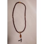 A string of horn and faux horn mala beads with a carved nut kernel feature bead in the form of