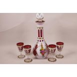 A Bohemian white on red flash cut decanter and four matching glasses, with hand painted enamel