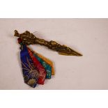A Sino-Tibetan ceremonial brass phurba, the handle decorated with three faces of wrathful deities,