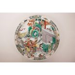 A Chinese famille verte porcelain charger decorated with warriors on horseback, 6 character mark