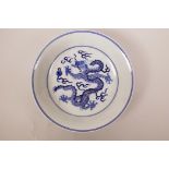 A Chinese blue and white porcelain dish decorated with dragons chasing the flaming pearl, seal