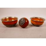 Two faux amber bowls with white metal mounts and repoussé decoration of the eight Buddhist