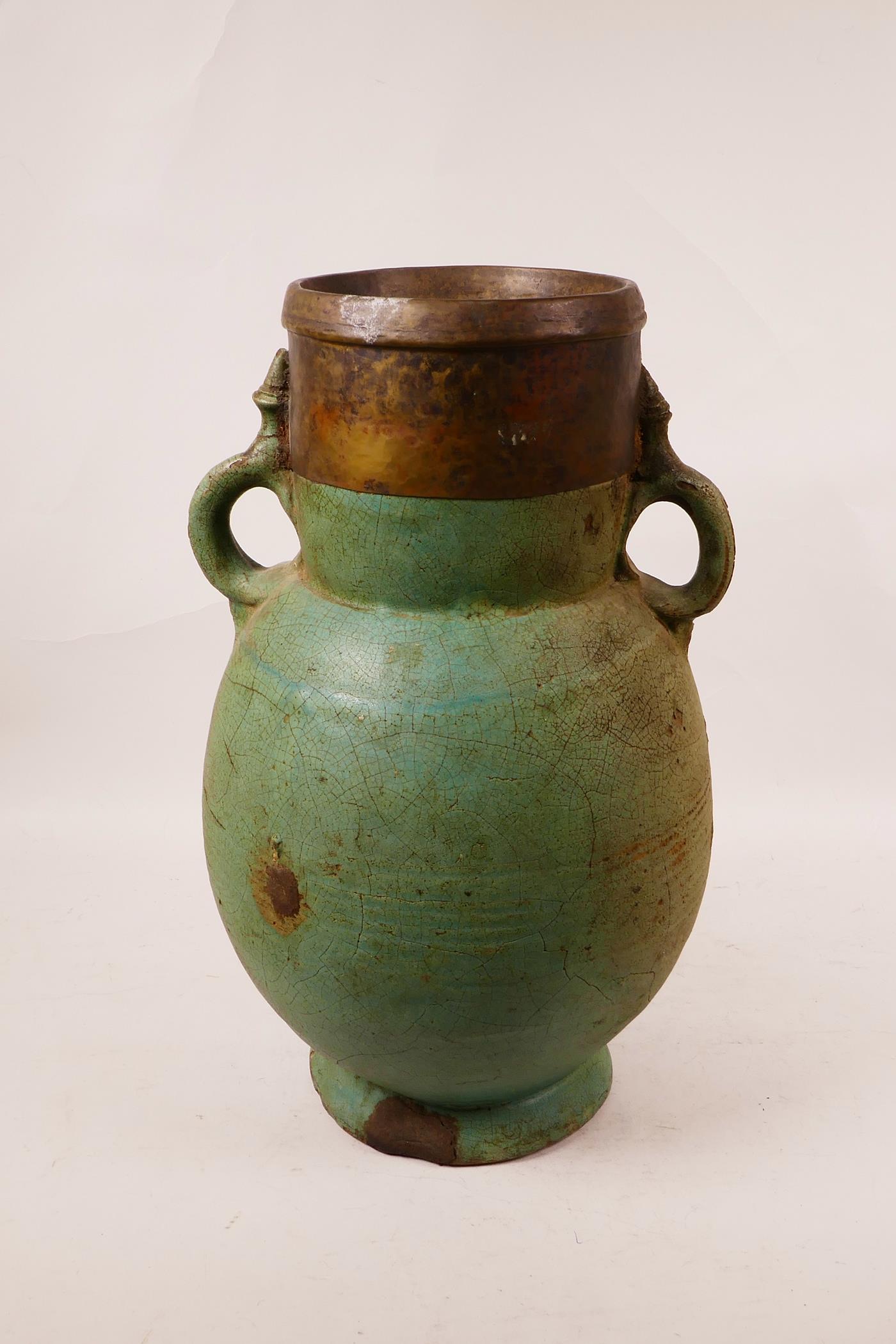 An Eastern pottery two handled vase with a turquoise glaze and copper rim, probably Indian, repair