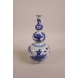 A Chinese blue and white porcelain triple gourd vase decorated with objects of virtu, mark to