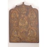 A Tibetan carved wood wall shrine inset with brass mounts in the form of Buddha, 10" x 7½"